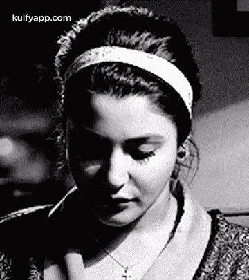 a black and white photo of a woman wearing headphones and a headband .