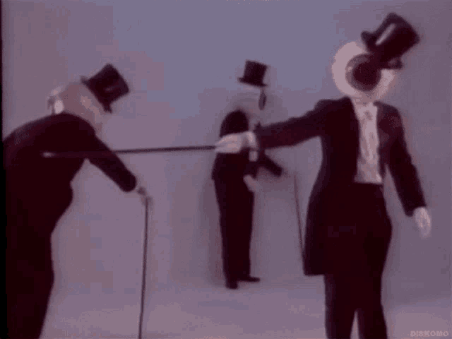 three men wearing top hats and walking canes are standing next to each other ..