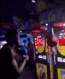 a man is playing a game in an arcade with a sign that says ' r & r ' on it