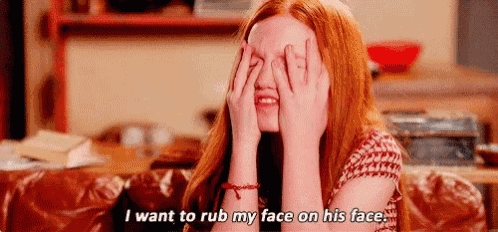 a woman with red hair is covering her eyes with her hands .