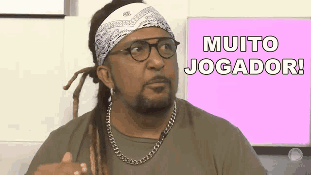 a man with dreadlocks wearing glasses and a bandana says " muito jogador "