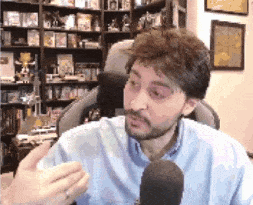 a man with a beard is talking into a microphone