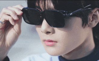 a close up of a person wearing sunglasses and a ring