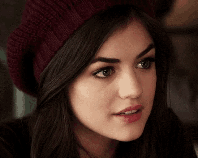 a close up of a woman 's face wearing a hat