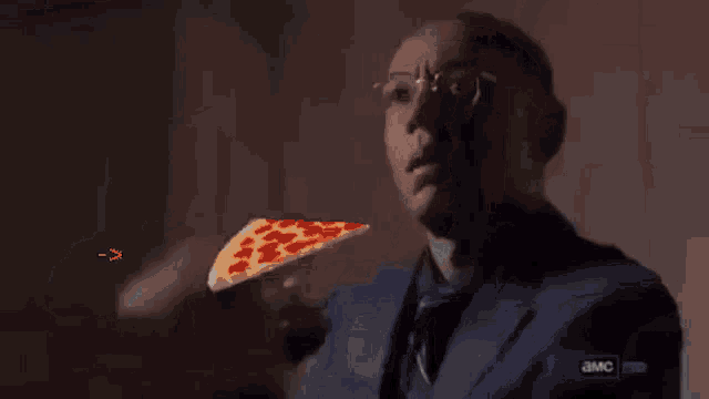 a man is holding a slice of pizza in front of him