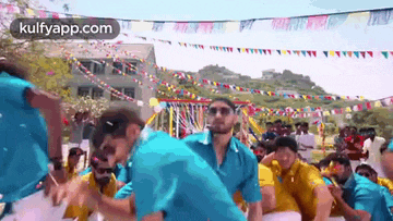 a group of men are dancing in front of a crowd of people at a party .