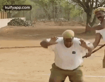 a man is being attacked by another man while holding a stick .