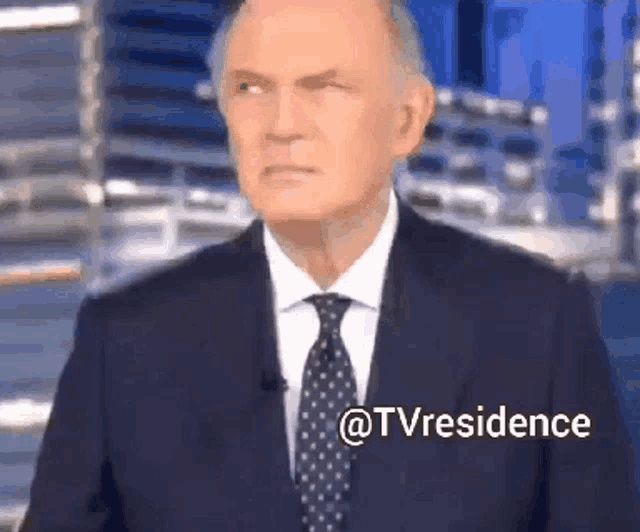 a man in a suit and tie is standing in front of a screen that says ' @tvresidence ' on it