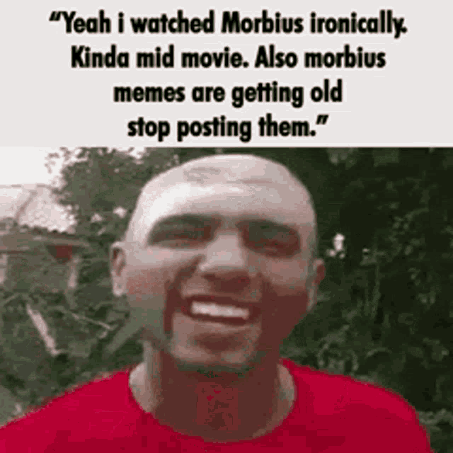 a bald man in a red shirt is smiling with a caption that says `` yeah i watched morbidus ironically .