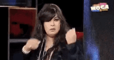a woman with long hair is making a funny face in front of a sign that says moga on it .