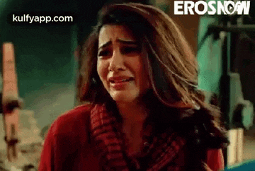 a woman in a red sweater is crying .