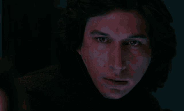 a close up of a man 's face with a red light behind him .