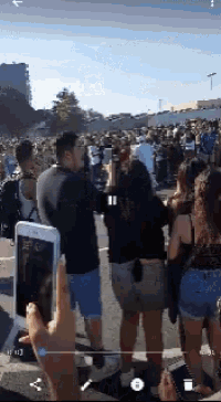 a person is taking a picture of a crowd of people with their phone