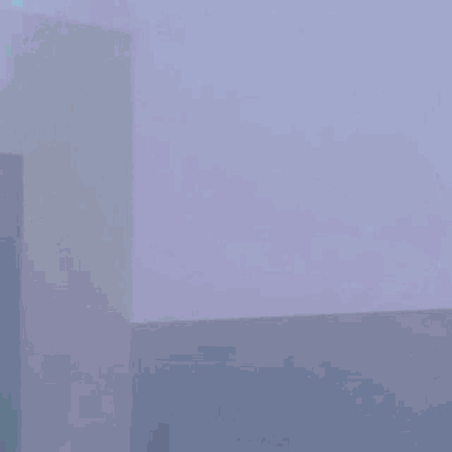 a person is standing in a dark room with blue curtains behind them