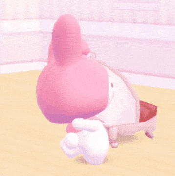 a pink bunny with a white bow on its head is laying on a table