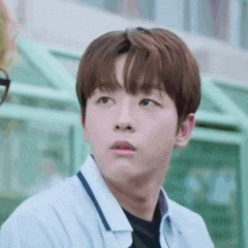 a close up of a young man 's face with a shocked look on his face .