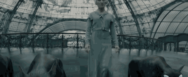 a woman in a blue dress stands in front of a dome