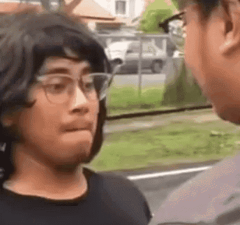 a man wearing glasses is talking to another man .