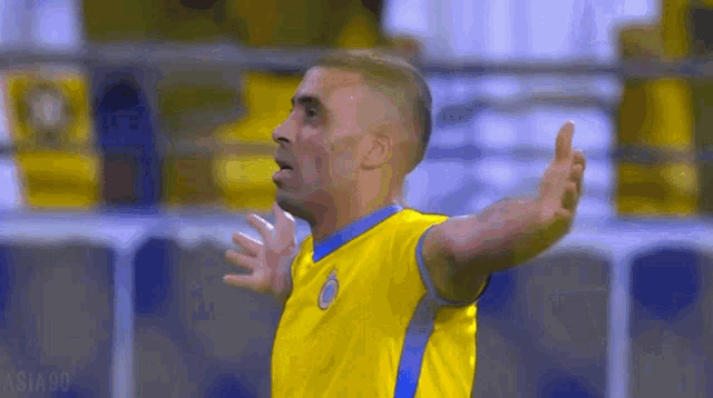 a soccer player in a yellow and blue jersey is giving the thumbs up sign