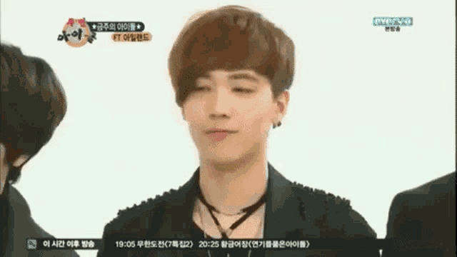 a young man is making a funny face in front of a group of people .