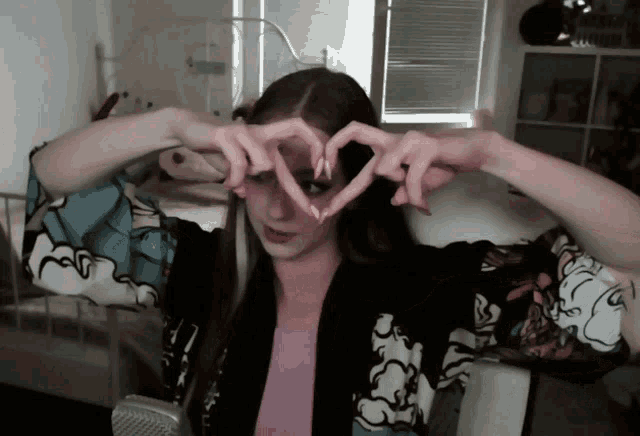 a girl making a heart shape with her hands