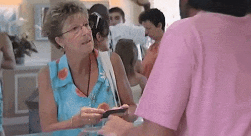 a woman in a pink shirt talks to a man in a blue shirt
