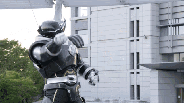 a robot is standing in front of a building and pointing