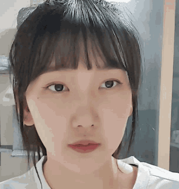 a close up of a girl 's face with a white shirt