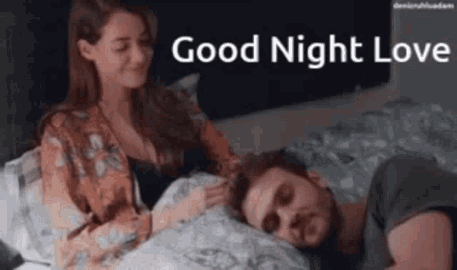 a woman is petting a man 's head while he sleeps in bed .