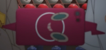a pink object with a smiley face on it is sitting on a table next to a bunch of bowling balls .