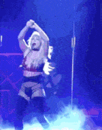 a woman in lingerie is dancing on a stage in front of a blue background