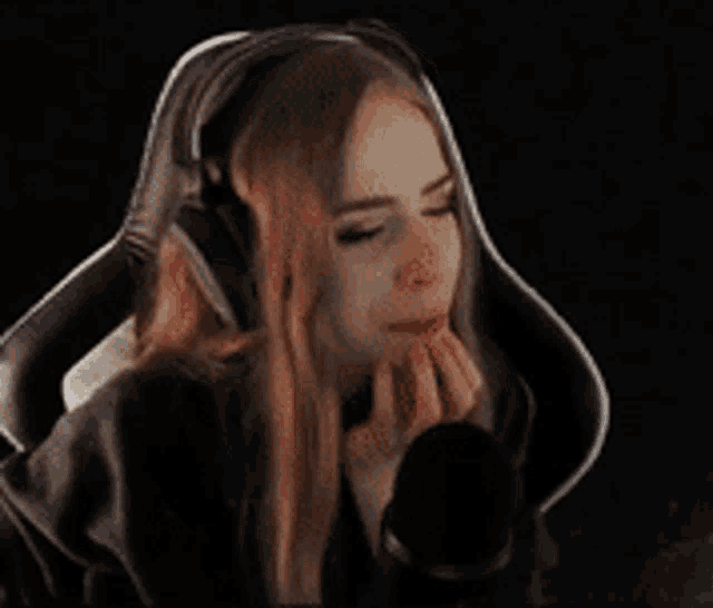 a woman wearing headphones is sitting in a chair and saying no