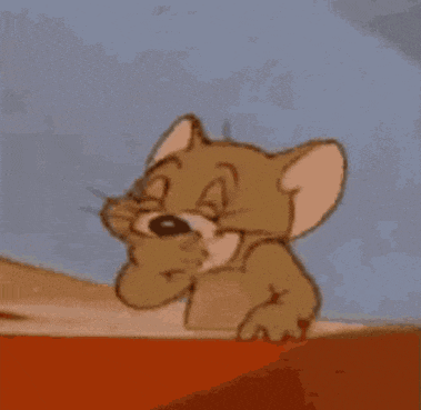 jerry from tom and jerry is making a funny face while standing on a table .