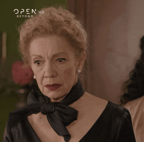 a woman wearing a black dress and a black scarf is featured on open hd beyond