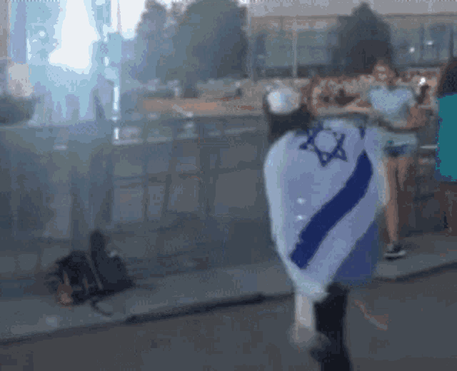 a person with a star of david on their back is walking down a street