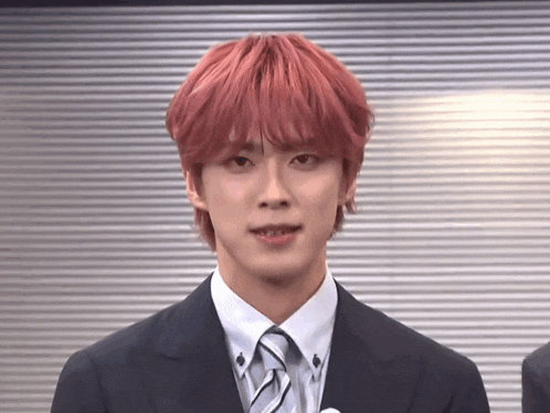 a man with red hair and a suit and tie