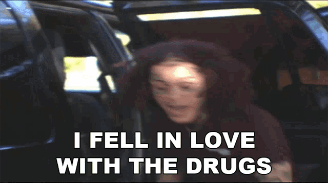 a man in a car with the words " i fell in love with the drugs " below him