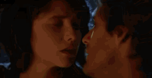 a man and a woman are standing next to each other with their mouths open .