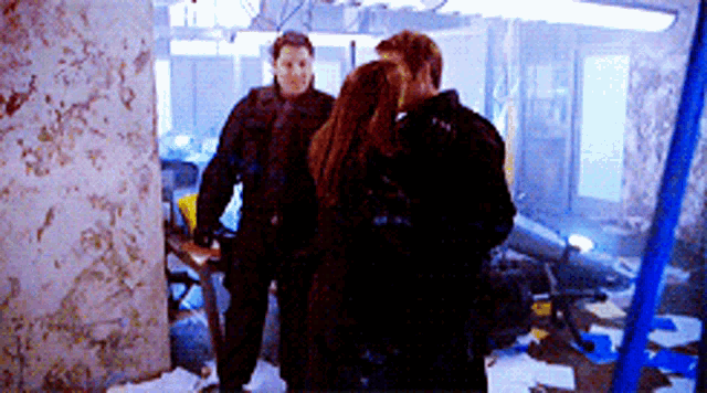 a man and a woman are standing in a room