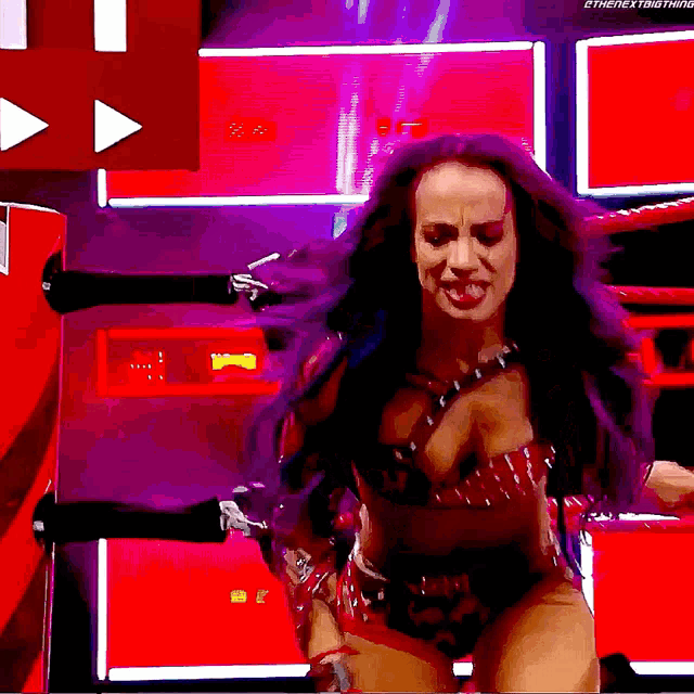 a woman with purple hair is standing in a boxing ring ..