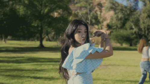 a woman in a blue dress is standing in the grass