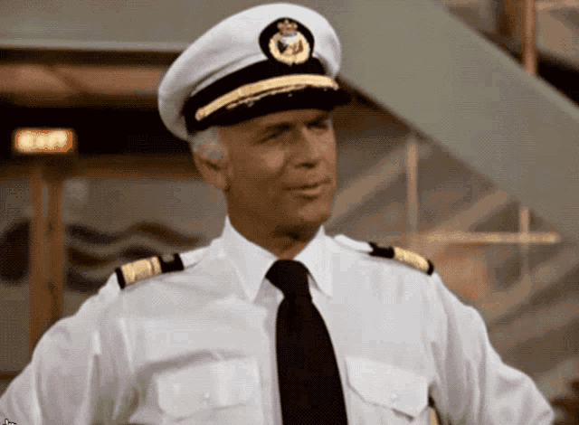 a man in a white shirt and black tie is wearing a white hat