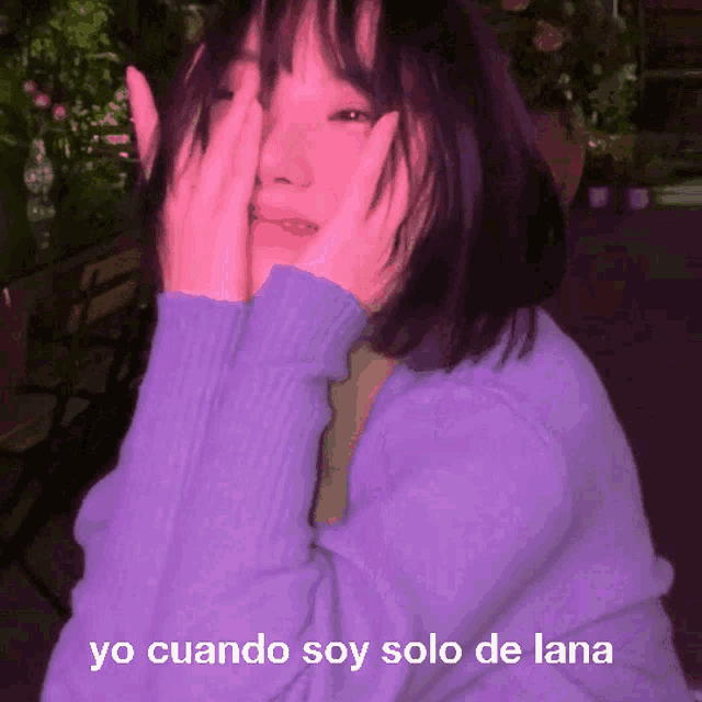 a girl in a purple sweater is covering her face with her hands and the words yo cuando soy solo de lana are above her