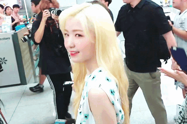 a woman with blonde hair is standing in front of a store that says instore on it