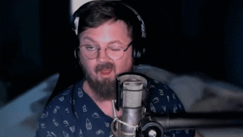 a man with a beard is singing into a microphone .