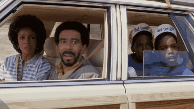 a group of people wearing del tongo hats are in a car