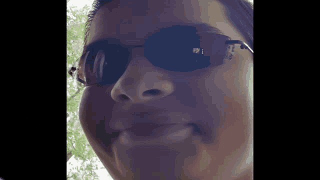 a close up of a person wearing sunglasses with a reflection of the letter i