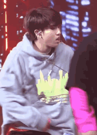a person wearing a hoodie with a city on it is standing next to another person