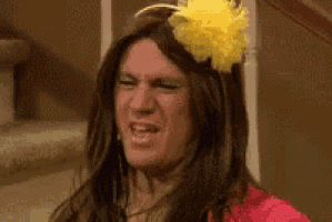 a man dressed as a woman with a yellow flower on his head .