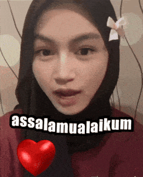 a woman wearing a hijab says " assalamualaikum " in front of a heart